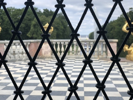 Looking through diamond-shaped bars onto Alexander's Park in Russia