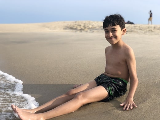 Mark lying on the sand at the beach